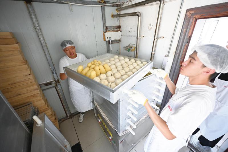 妈妈们让孩子们装袋、蒸煮面食、送货,孩子们十分认真(2)