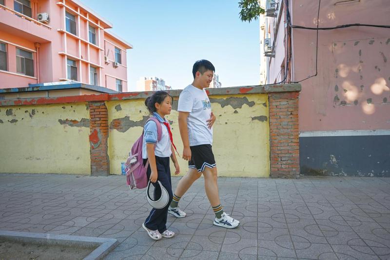 每天中午,吴英弘接妹妹放学